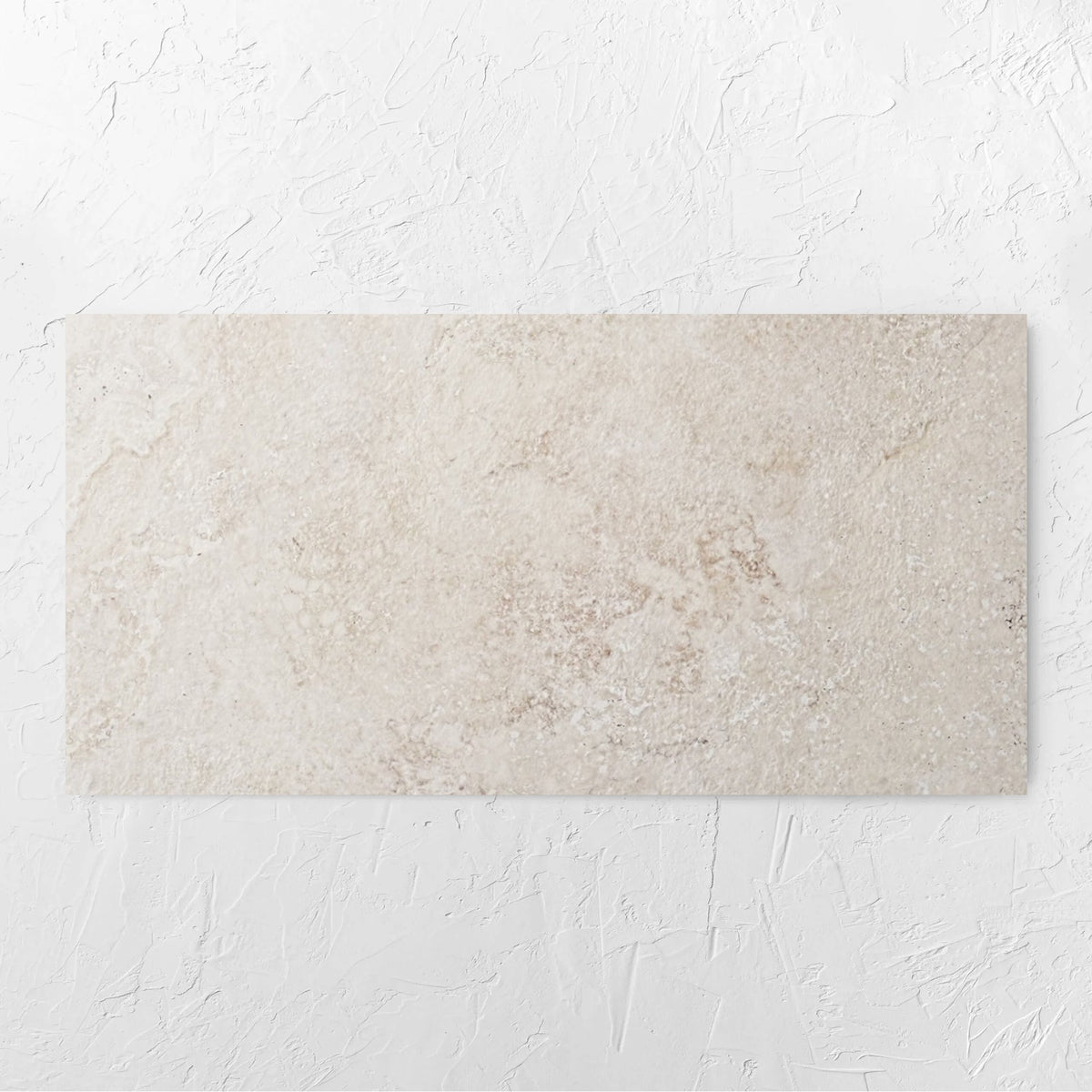 Norcia Travertine Beige 600x1200mm tile laid flat on a white rendered wall, showing the beige travertine surface