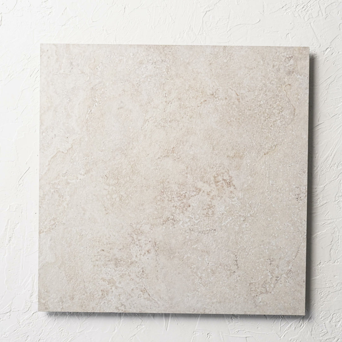Norcia Travertine Beige External Rectified Paver 600x600x20mm laid flat on a white rendered wall, showing the beige travertine surface