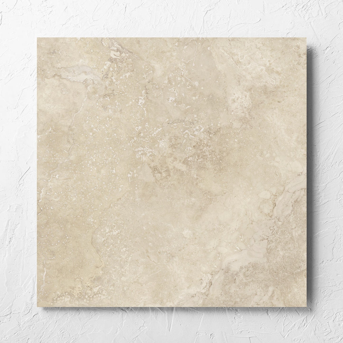 Norcia Travertine Beige Honed 600x600mm tile laid flat on a white rendered wall, showing the tile surface