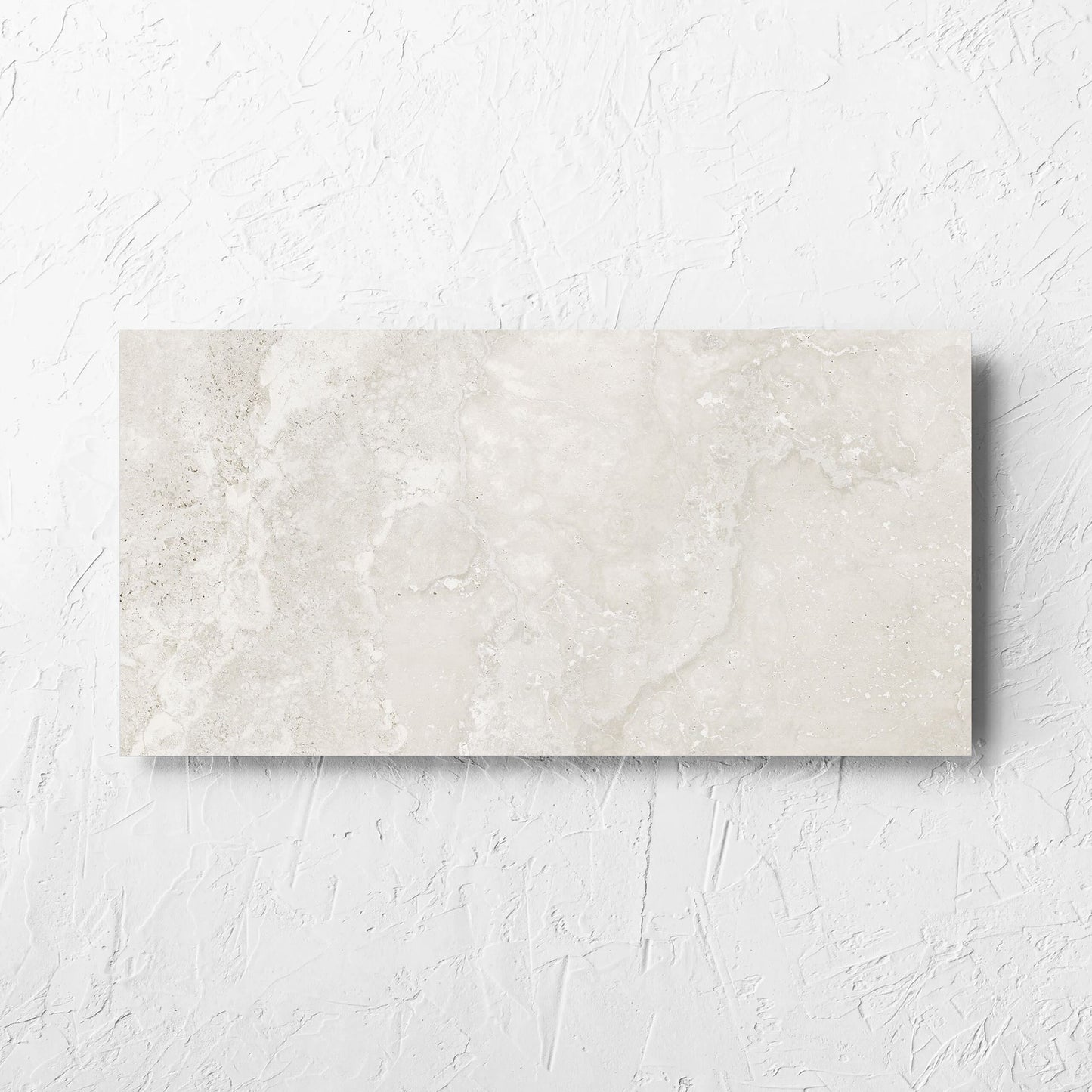 Norcia Travertine Light 300x600mm tile laid flat on a white rendered wall, showing the tile surface