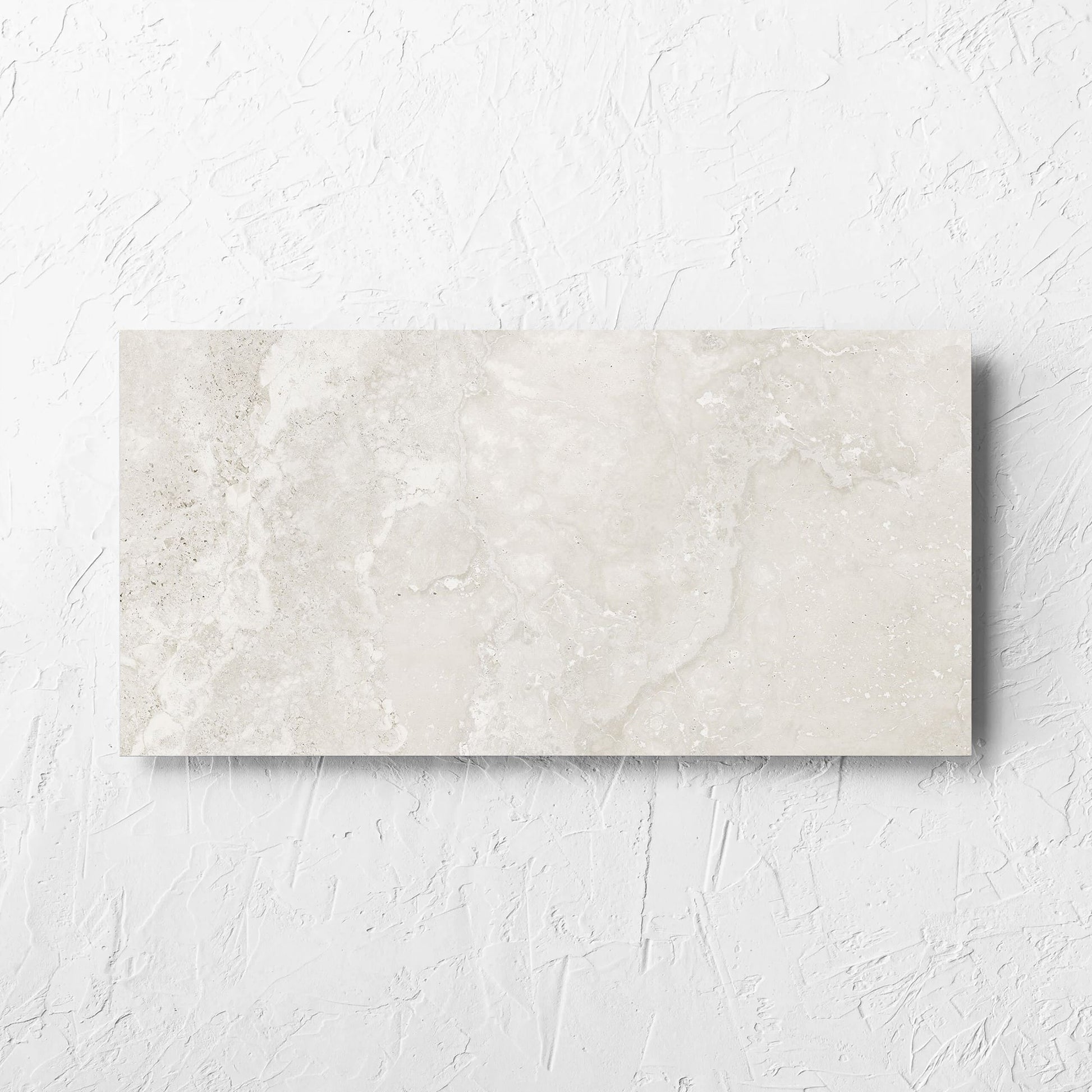 Norcia Travertine Light 300x600mm tile laid flat on a white rendered wall, showing the tile surface