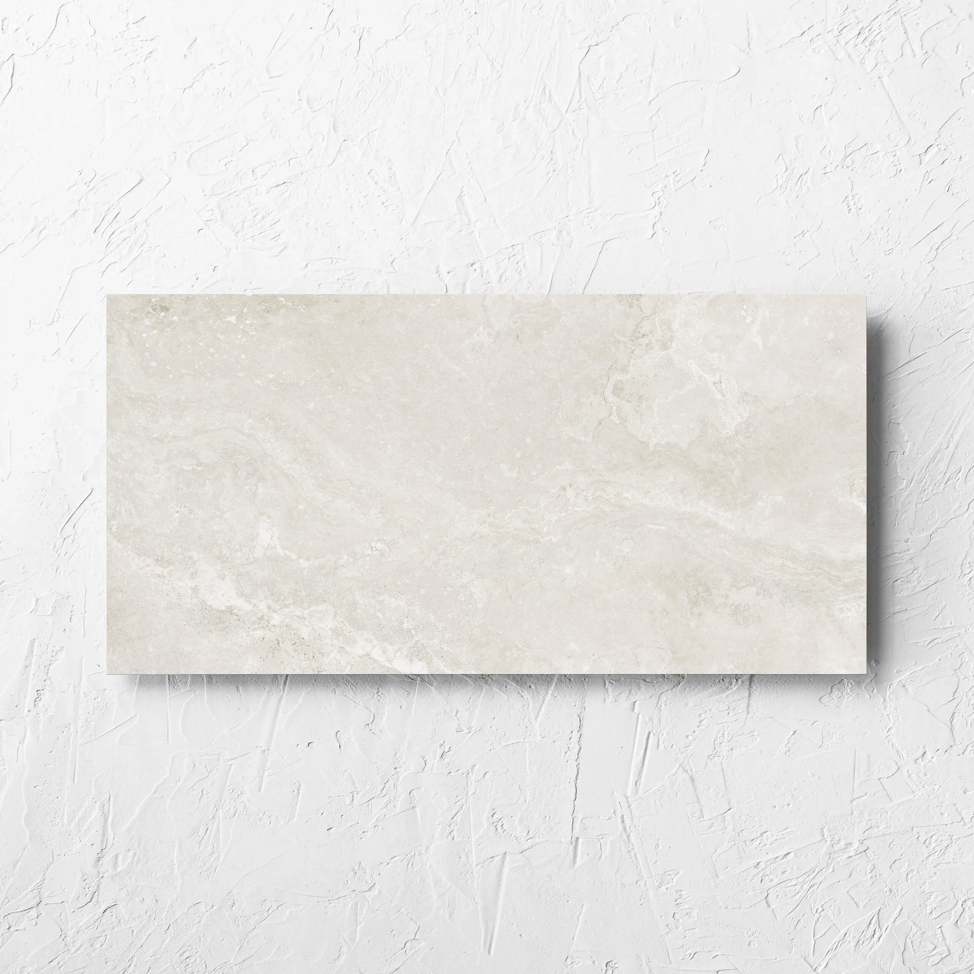 Norcia Travertine Light Decor 300x600mm tile laid flat on a white rendered wall, showing the tile surface