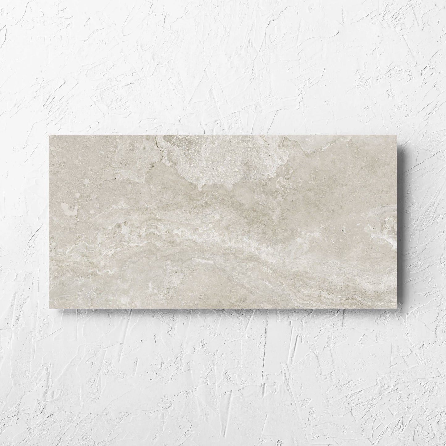 Norcia Travertine Silver 300x600mm tile laid flat on a white rendered wall, showing the tile surface