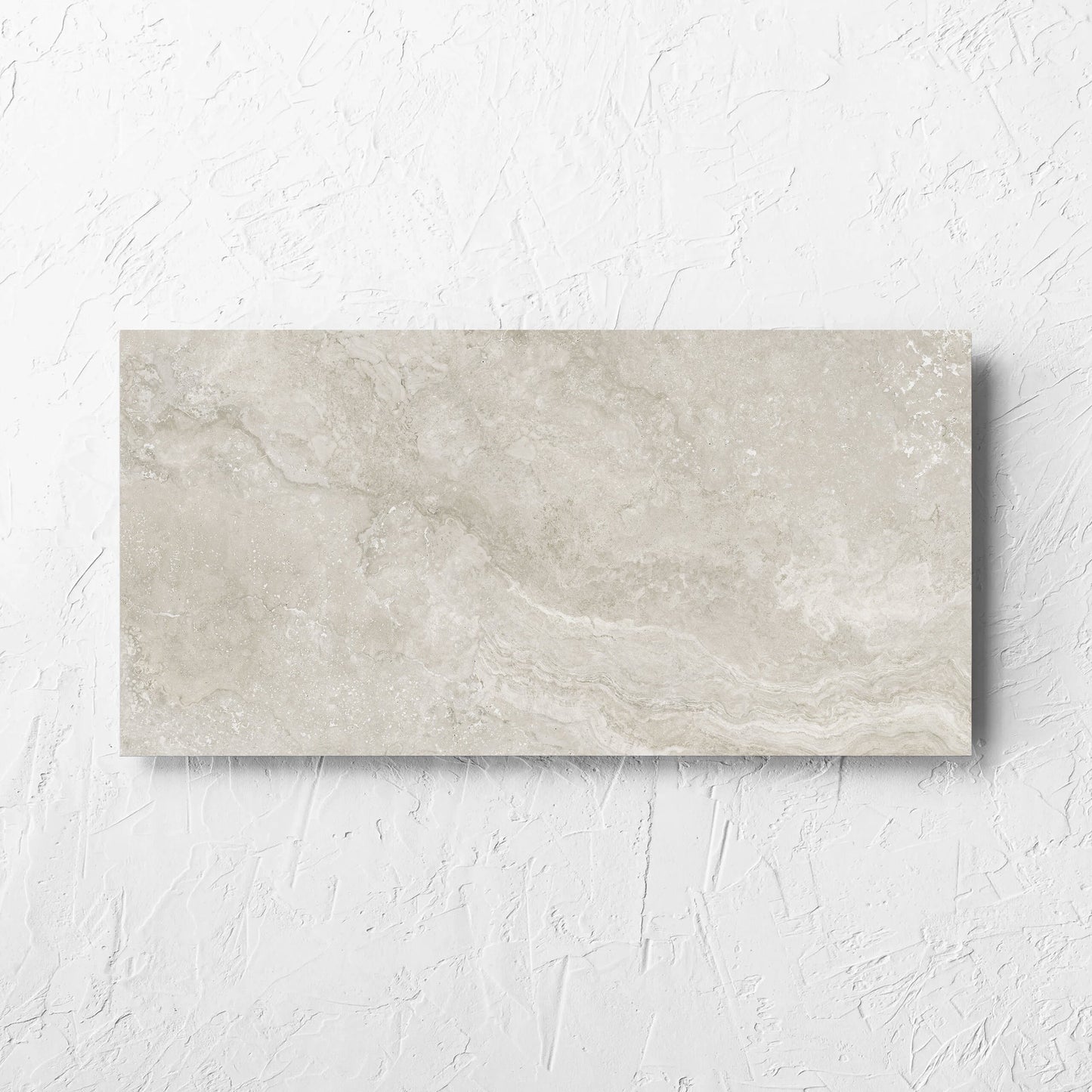 Norcia Travertine Silver Decor 300x600mm tile laid flat on a white rendered wall, showing the tile surface