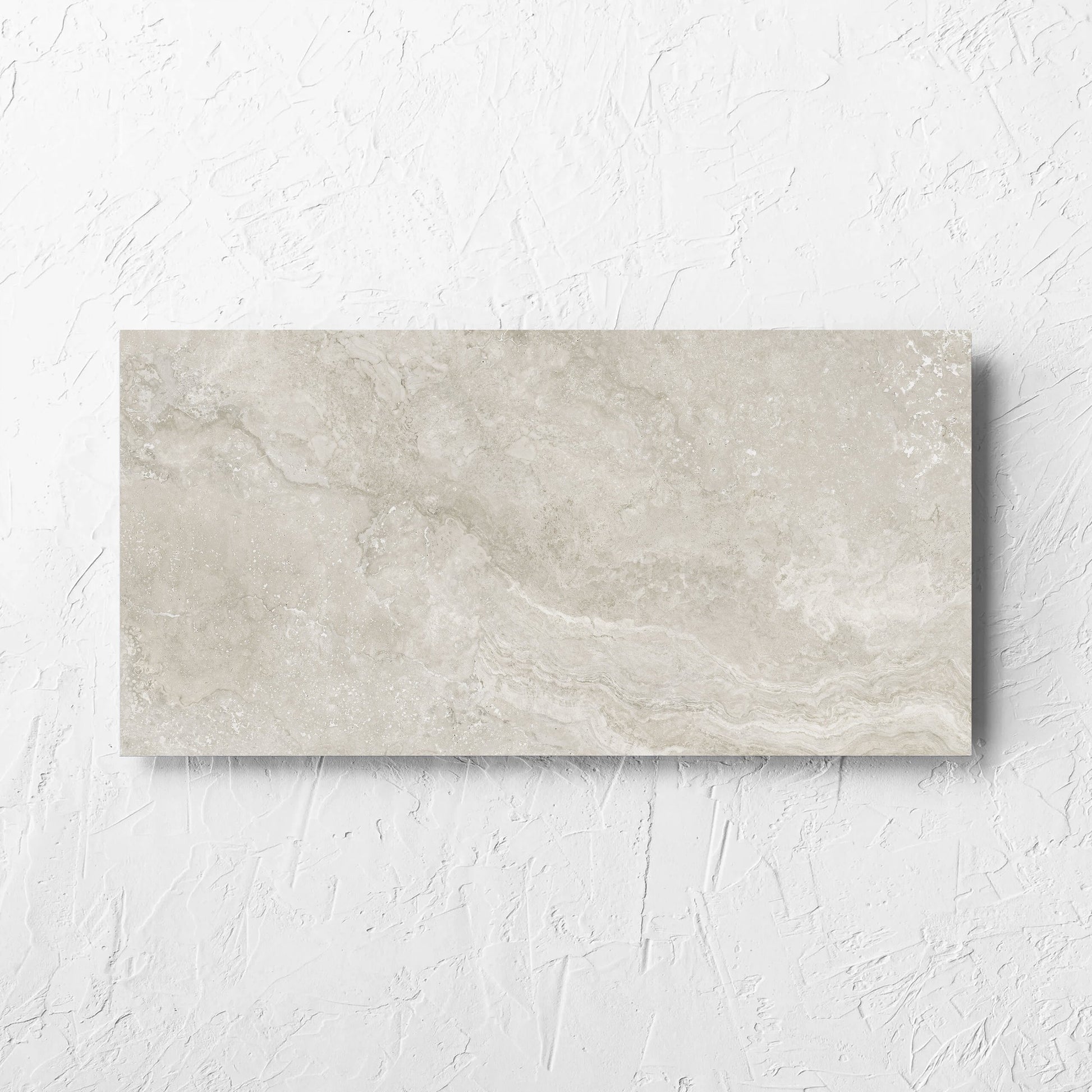 Norcia Travertine Silver Decor 300x600mm tile laid flat on a white rendered wall, showing the tile surface