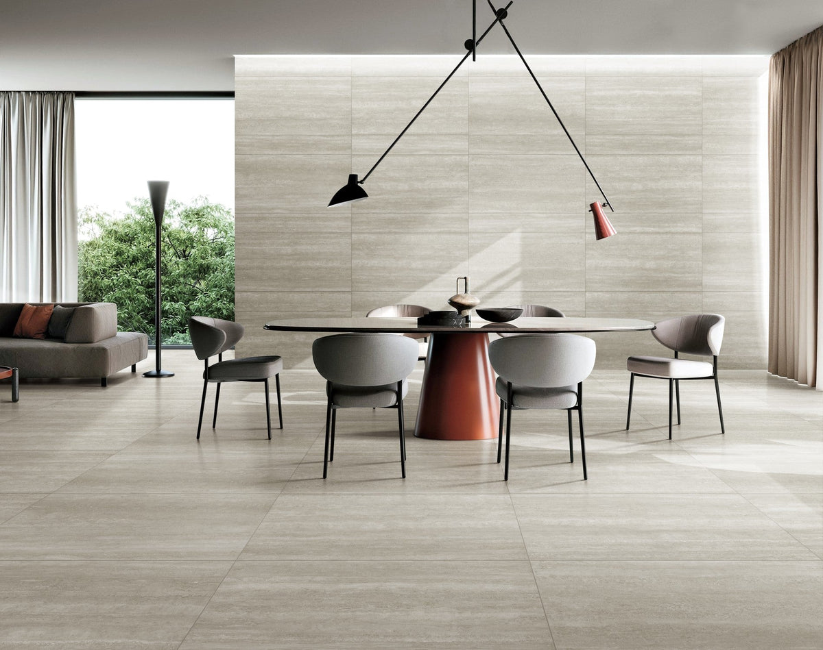 Norcia Vein Cut Beige porcelain tiles on the floor and feature wall of a contemporary dining room with a round table and pendant light