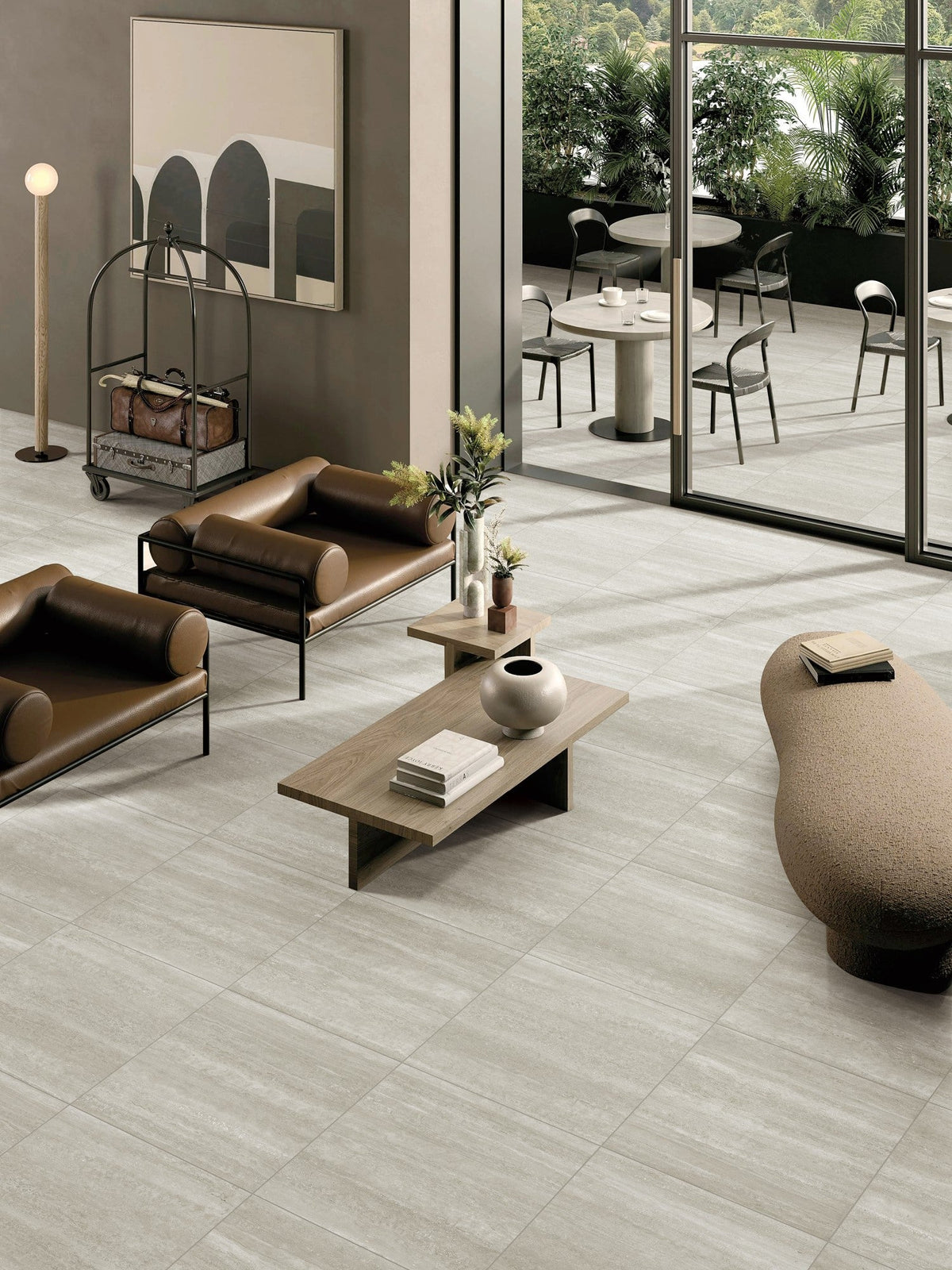 Norcia Vein Cut Beige tiles laid across a hotel lobby lounge with leather seating and a timber coffee table