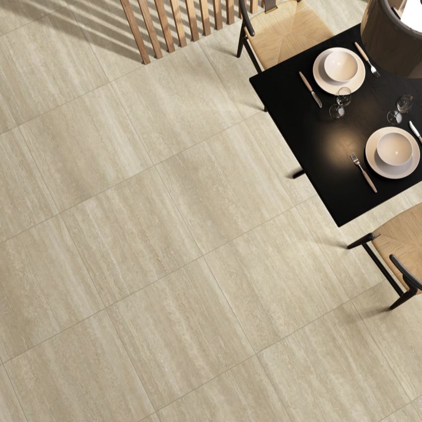 Overhead view of Norcia Vein Cut Beige tiles on a restaurant floor with a dark dining table and place settings