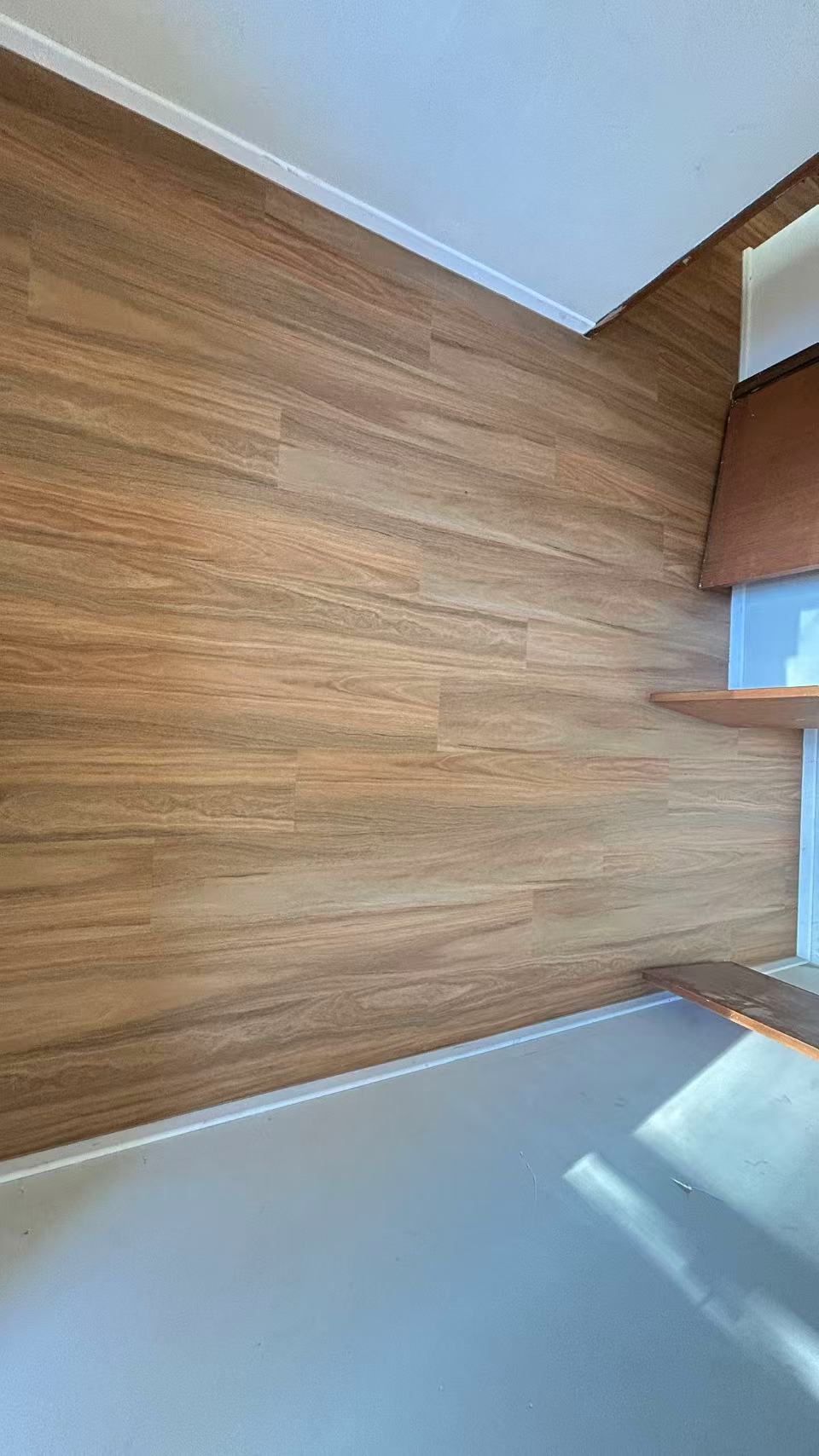 NSW Spotted Gum Elegant SPC Hybrid 6.5mm Flooring 5+1.5mm installed in an empty bedroom with warm honey-toned timber-look planks and timber floating shelves.