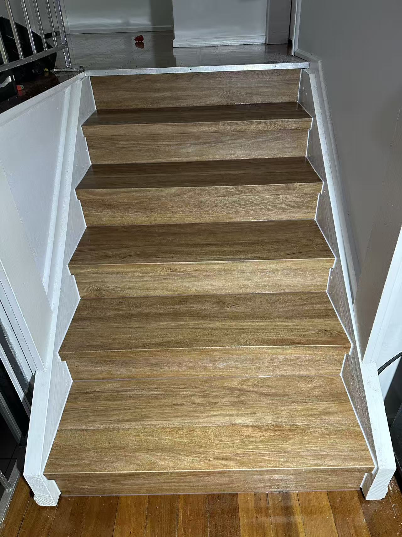 NSW Spotted Gum Elegant SPC Hybrid 6.5mm Flooring 5+1.5mm installed on indoor staircase treads and risers with white painted timber balustrade surrounds.