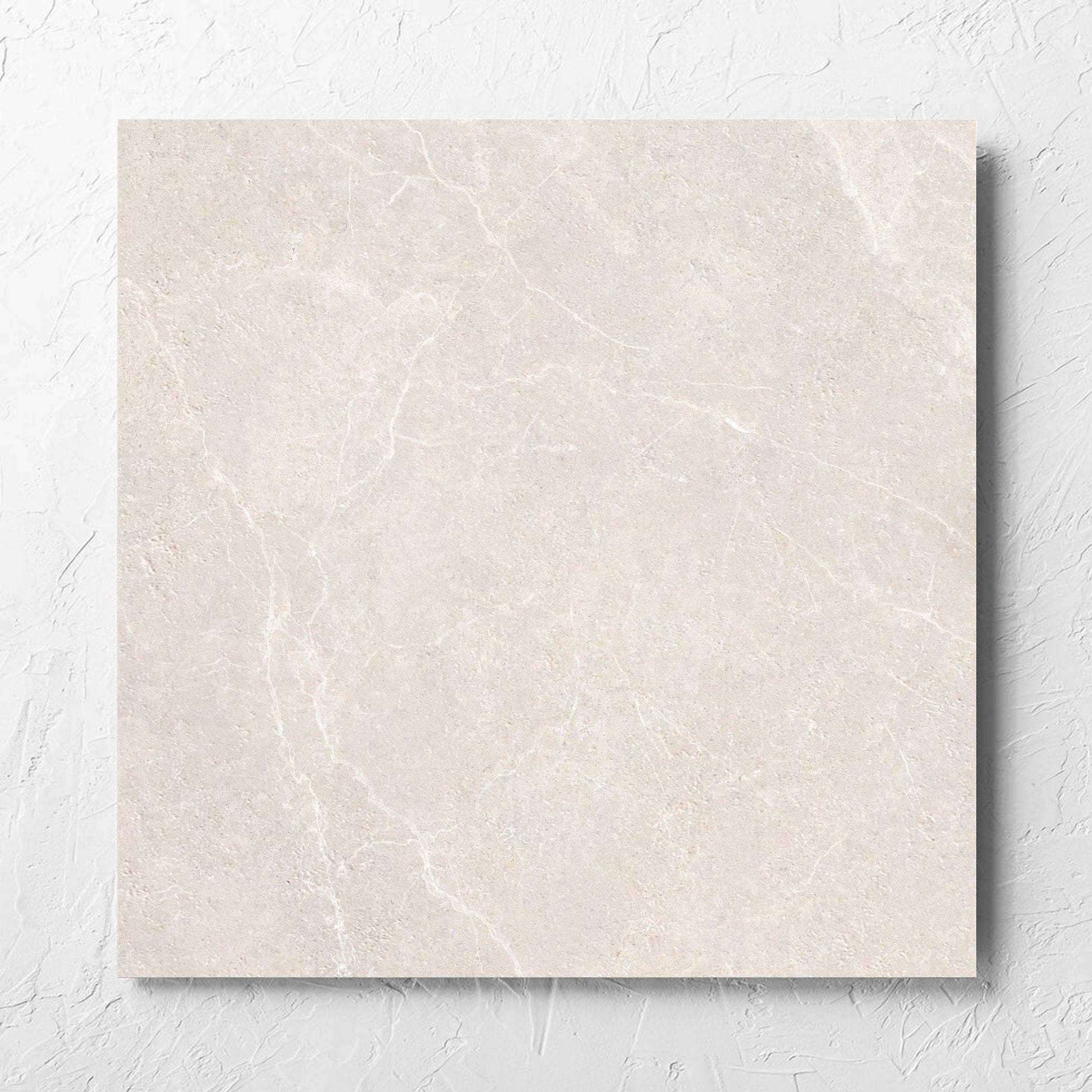 Oglio Beige 600x600mm tile laid flat on a white rendered wall, showing the beige in out non slip surface