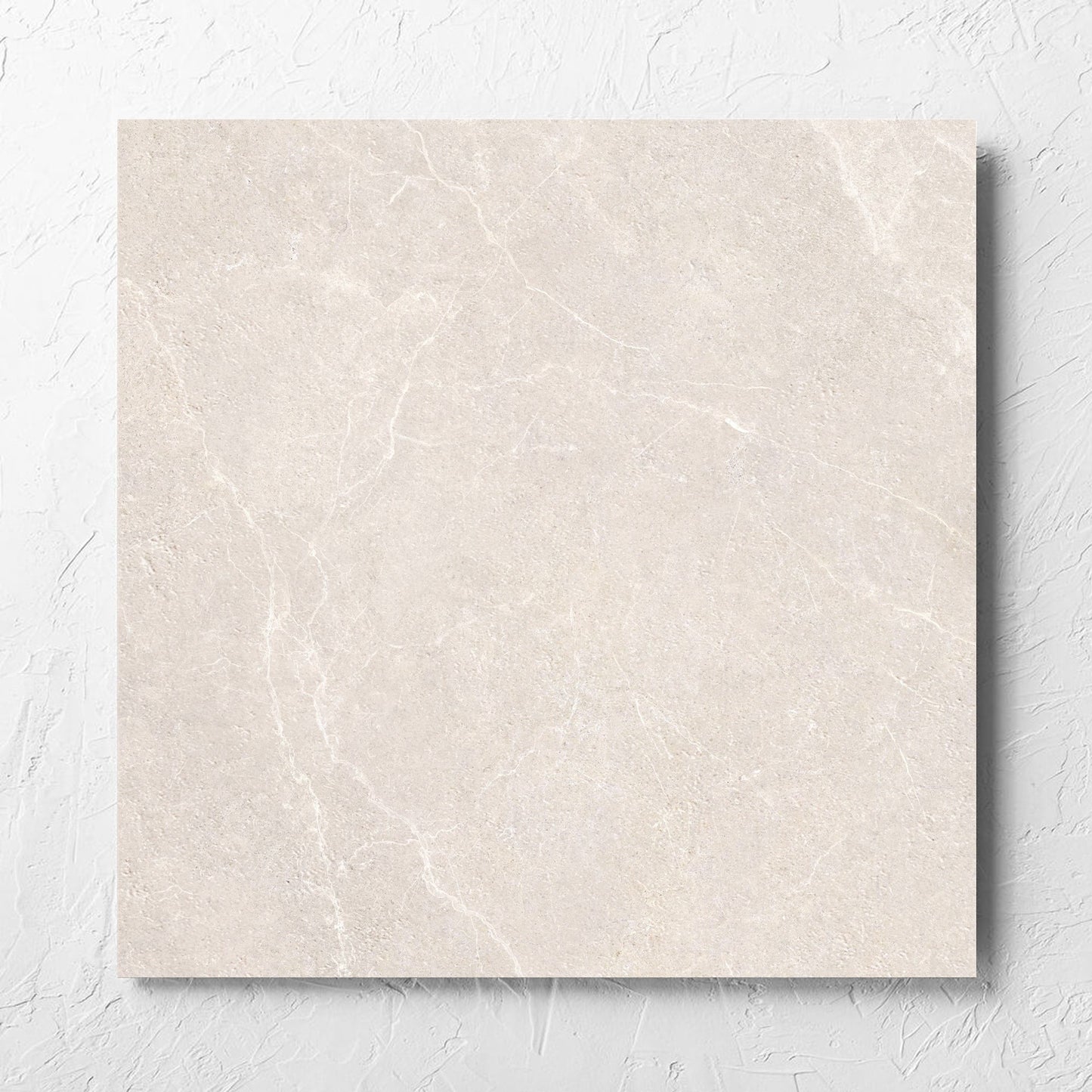 Oglio Beige Lappato 600x600mm tile laid flat on a white rendered wall, showing the lappato surface