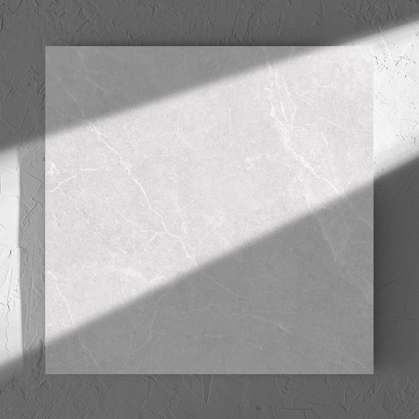 Oglio Silver 600x600mm tile in soft natural window light, showing the silver surface