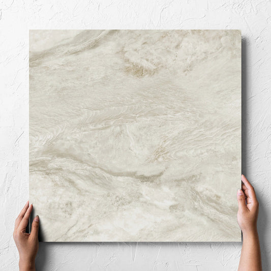 Hand holding a single Onyx Beige Matt 600x600mm tile against a white rendered wall, showing the matt surface