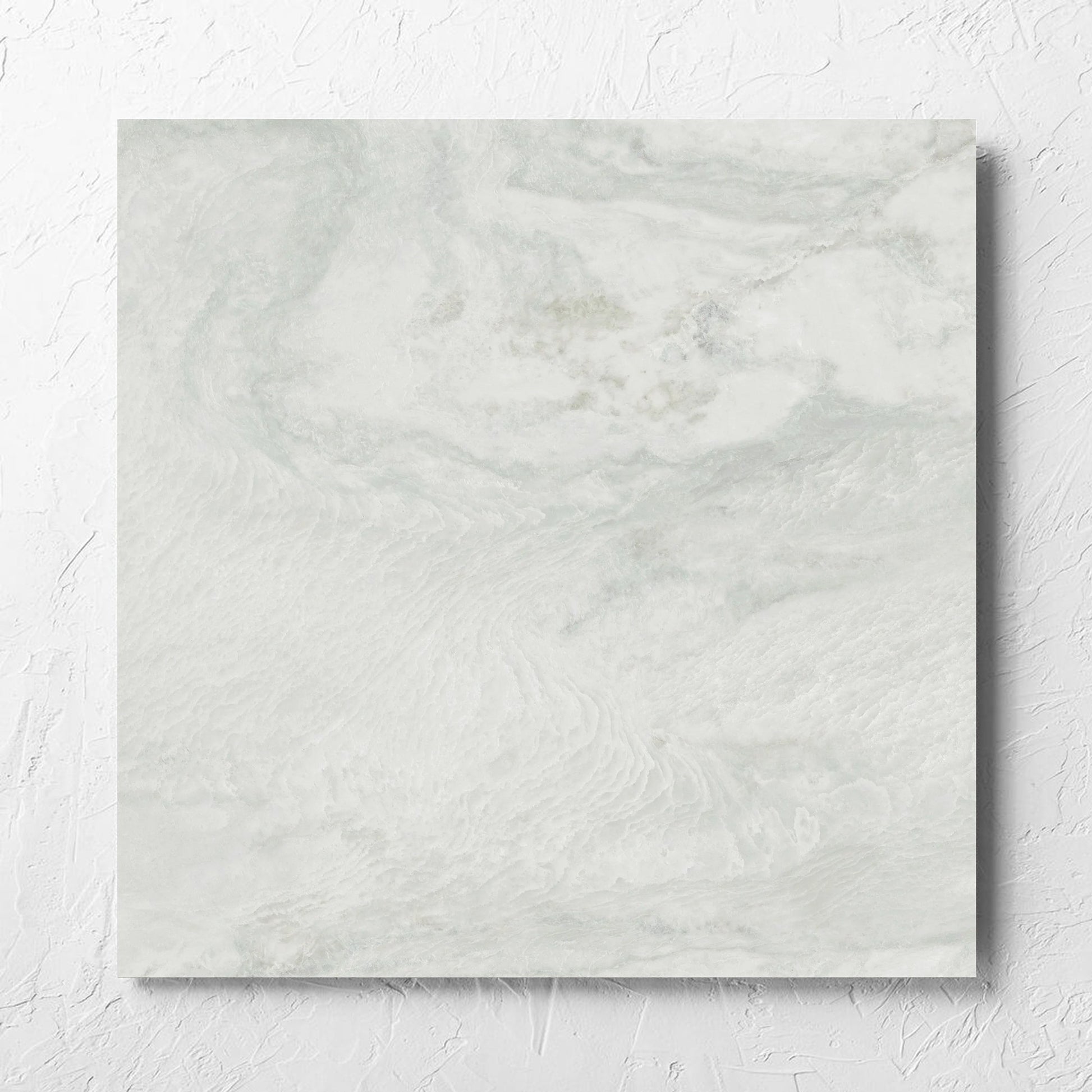 Onyx White Polished 600x600mm tile laid flat on a white rendered wall, showing the matt surface