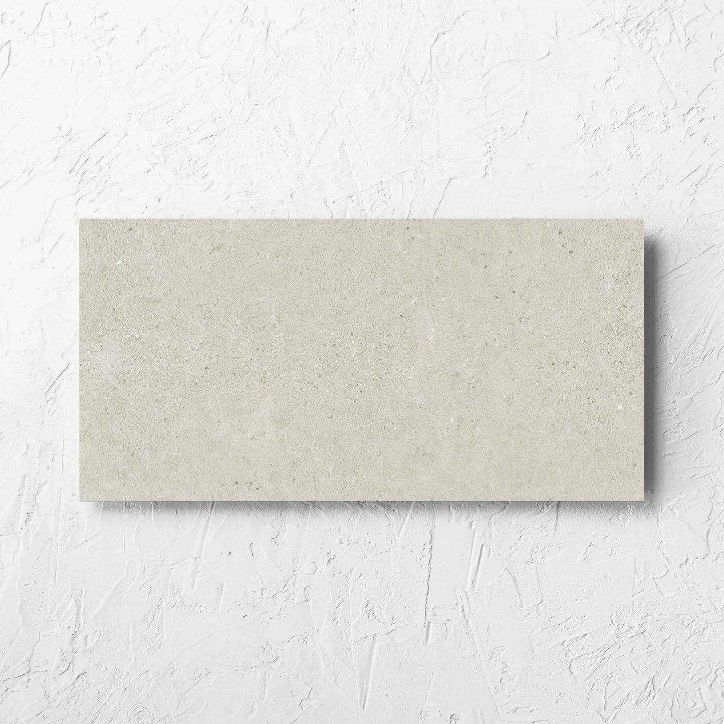 Organic Pietra Lavica Birch 300x600mm tile laid flat on a white rendered wall, showing the tile surface