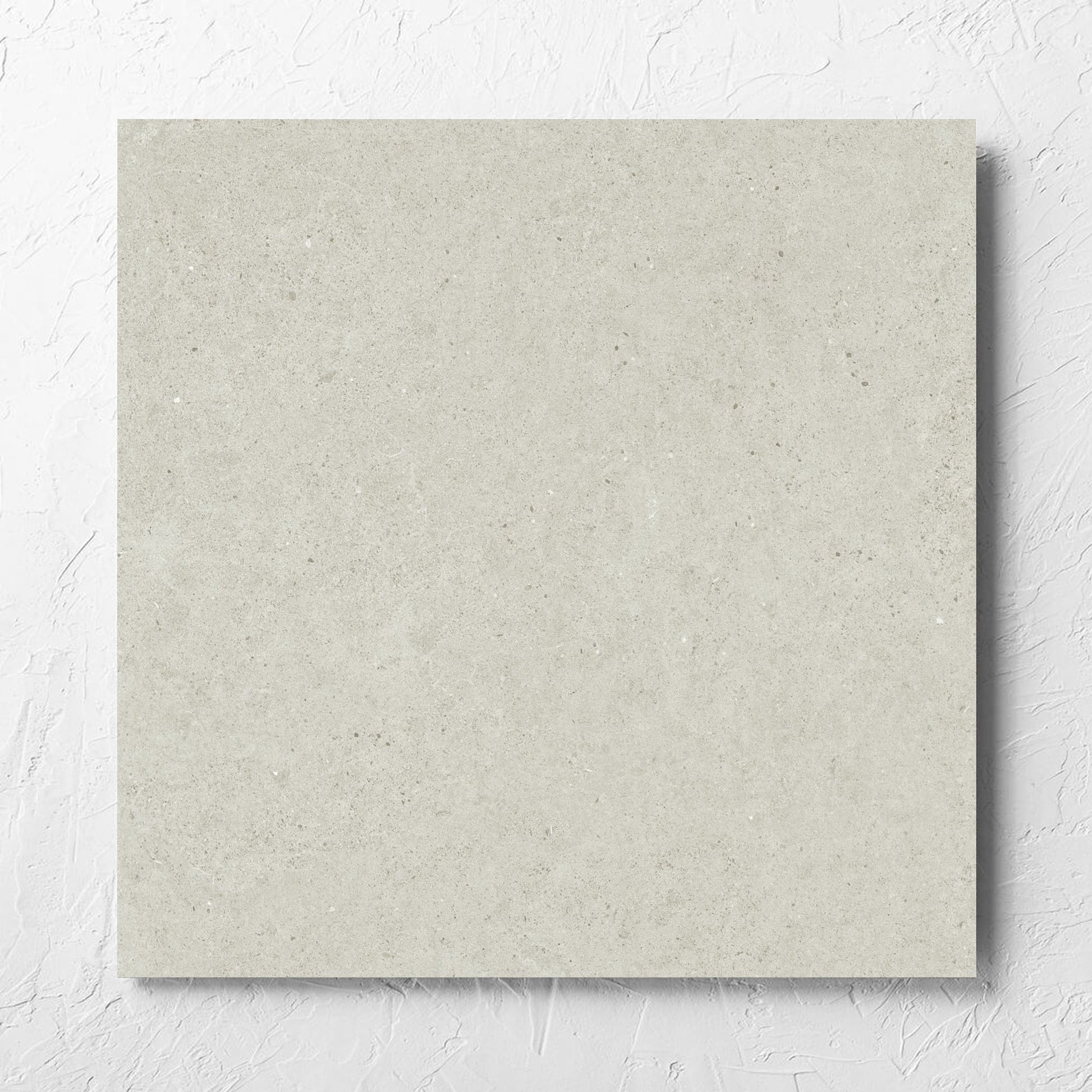 Organic Pietra Lavica Birch 600x600mm tile laid flat on a white rendered wall, showing the tile surface