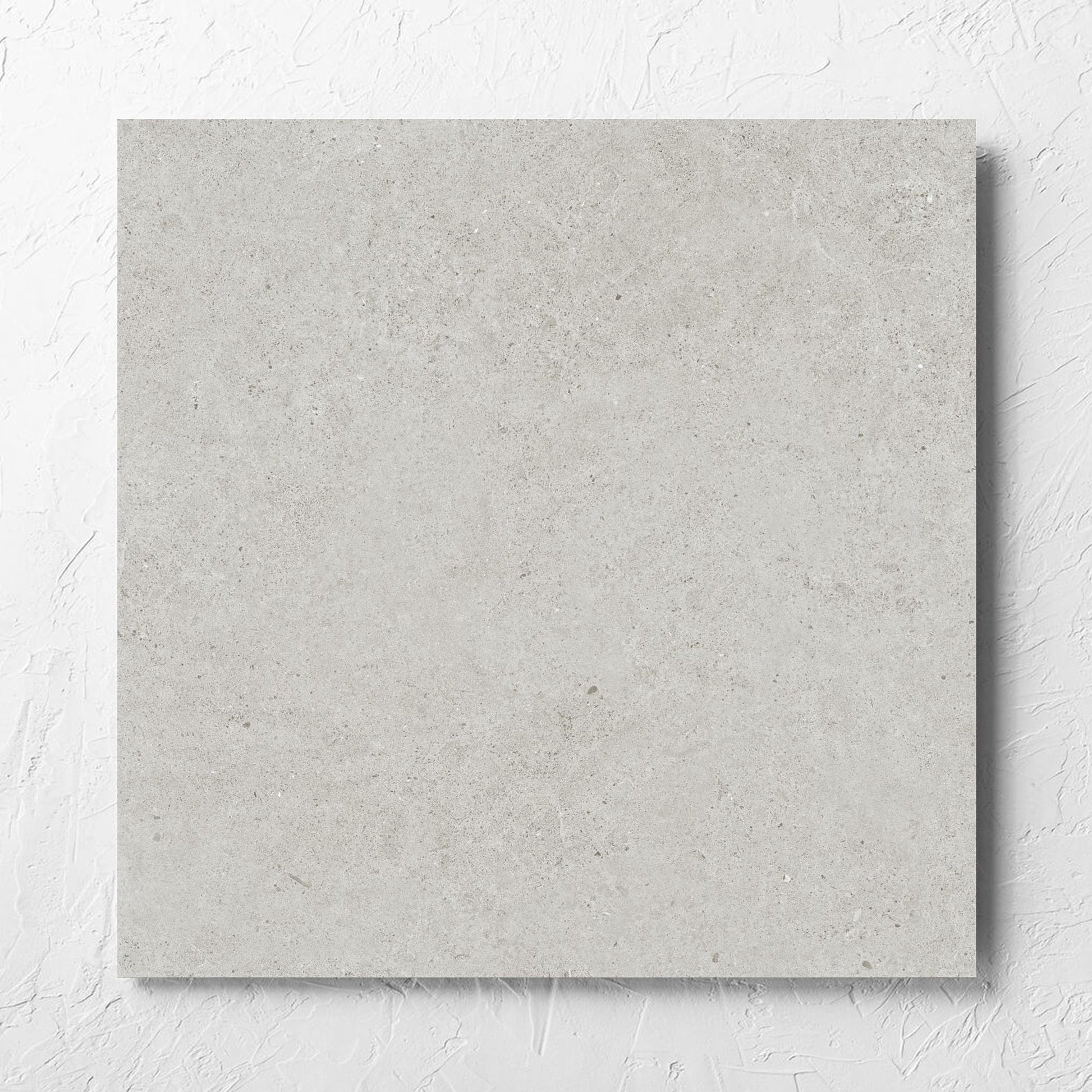 Organic Pietra Lavica Glacier Lappato 600x600mm tile laid flat on a white rendered wall, showing the tile surface