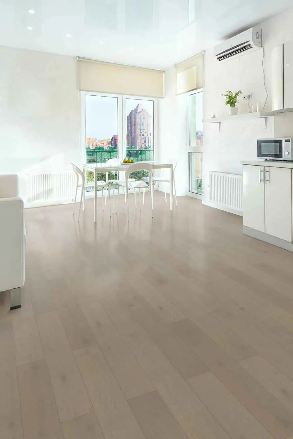 Pale Oak iDesign15 Oak Flooring 15/3mm installed in a bright open-plan living and dining area with white cabinetry, a glass dining table, and large floor-to-ceiling windows.