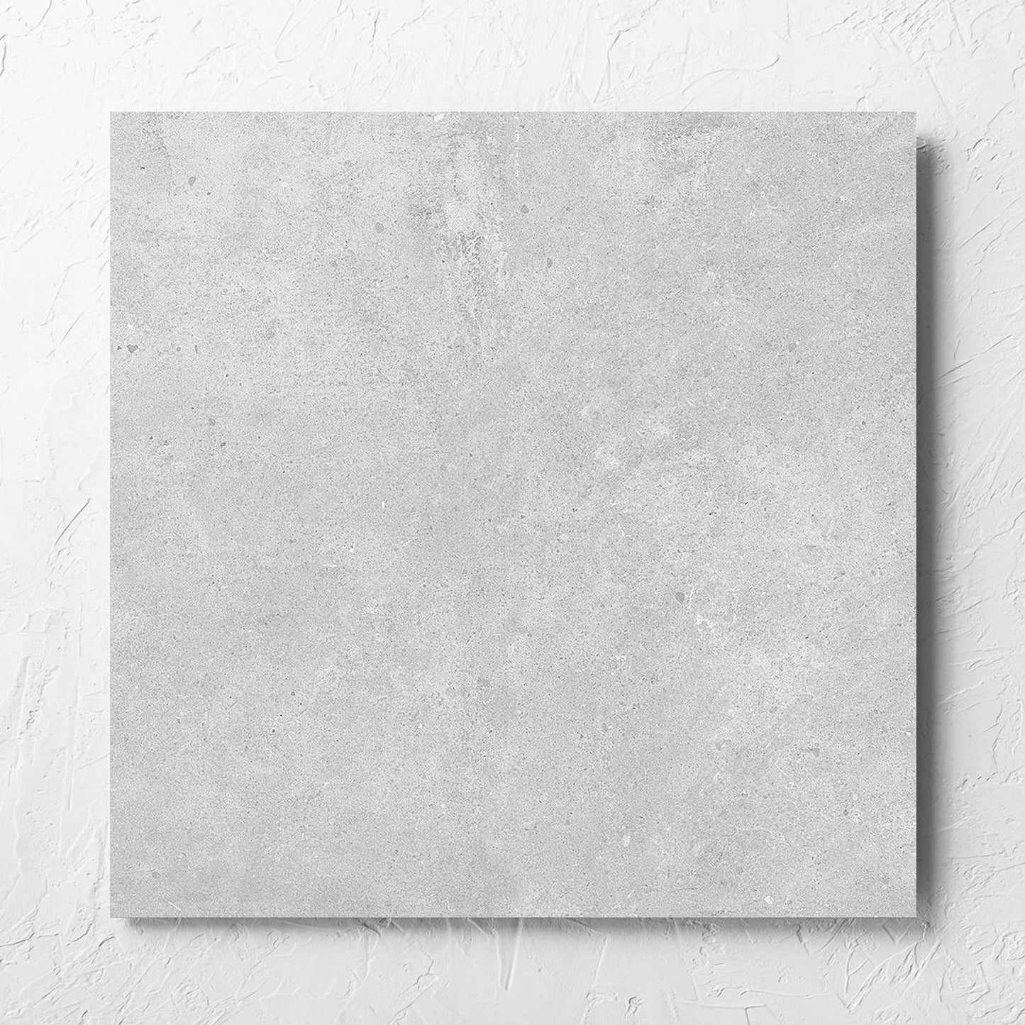 Paradigm Light Grey Structured Paver 600x600x20mm tile laid flat on a white rendered wall, showing the tile surface