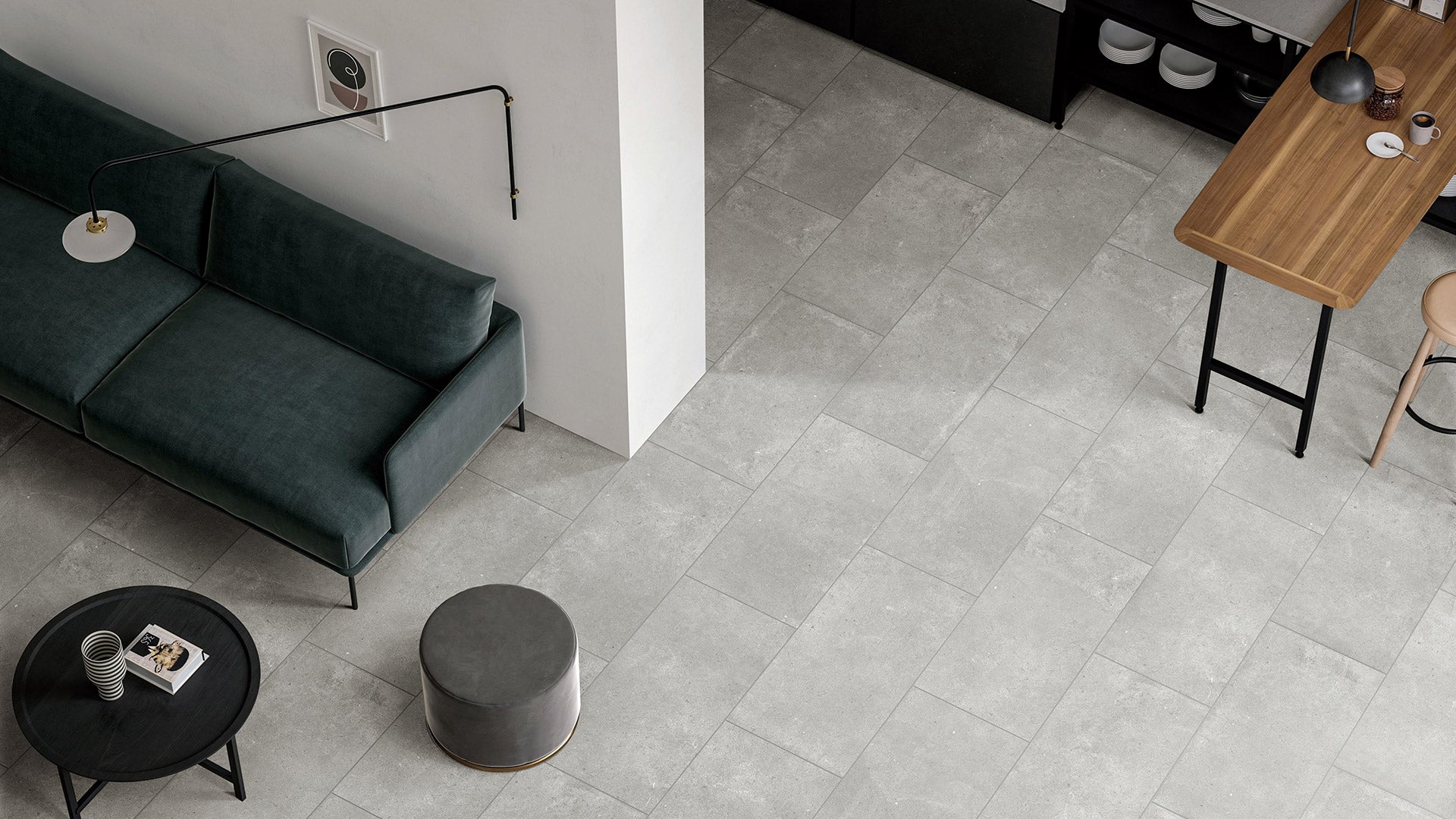 Paradigm Light Grey Structured Paver 600x600x20mm installed as open-plan living room floor with teal velvet sofa, round coffee table, and timber dining bar.