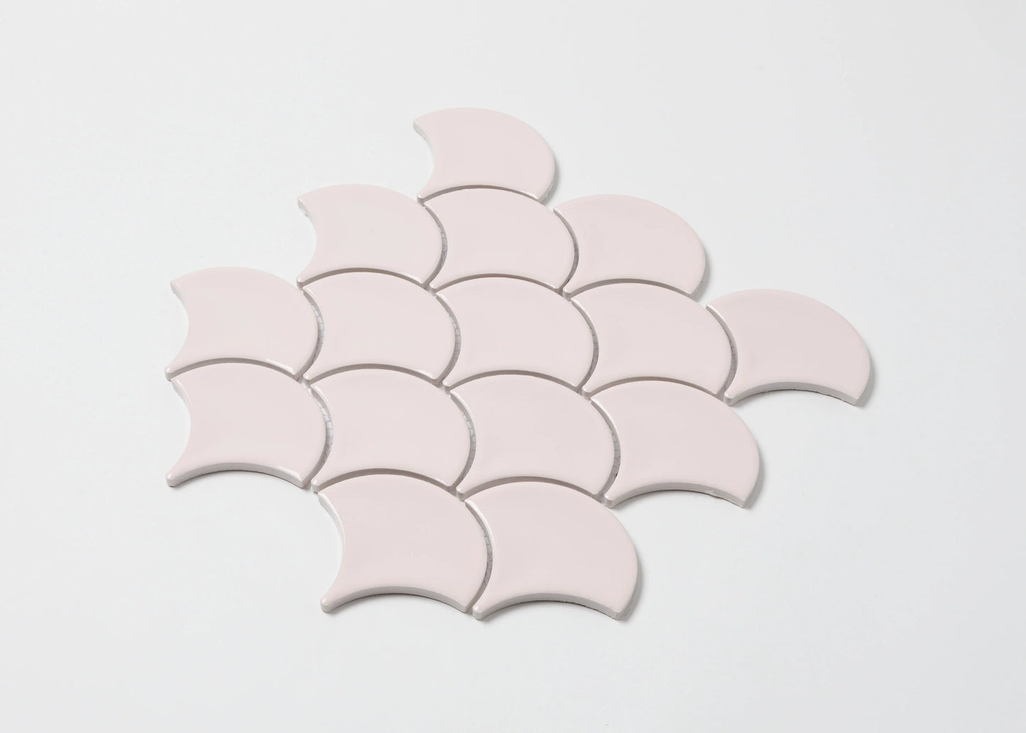 Pack shot of Pastel Pink Gloss Glazed Porcelain Fishscale 95x87mm tiles arranged in an overlapping scallop pattern showing their crescent shape and smooth glossy finish.