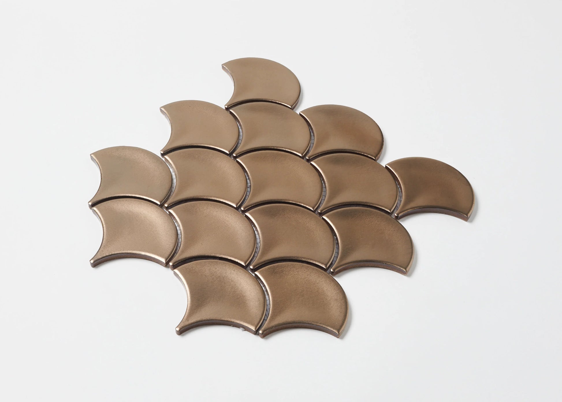 Pack shot of PGFS-0009 Bronze Metal Plated Matte Glazed Porcelain Fishscale tiles arranged in an overlapping scale pattern with a warm copper-bronze metallic matte finish.
