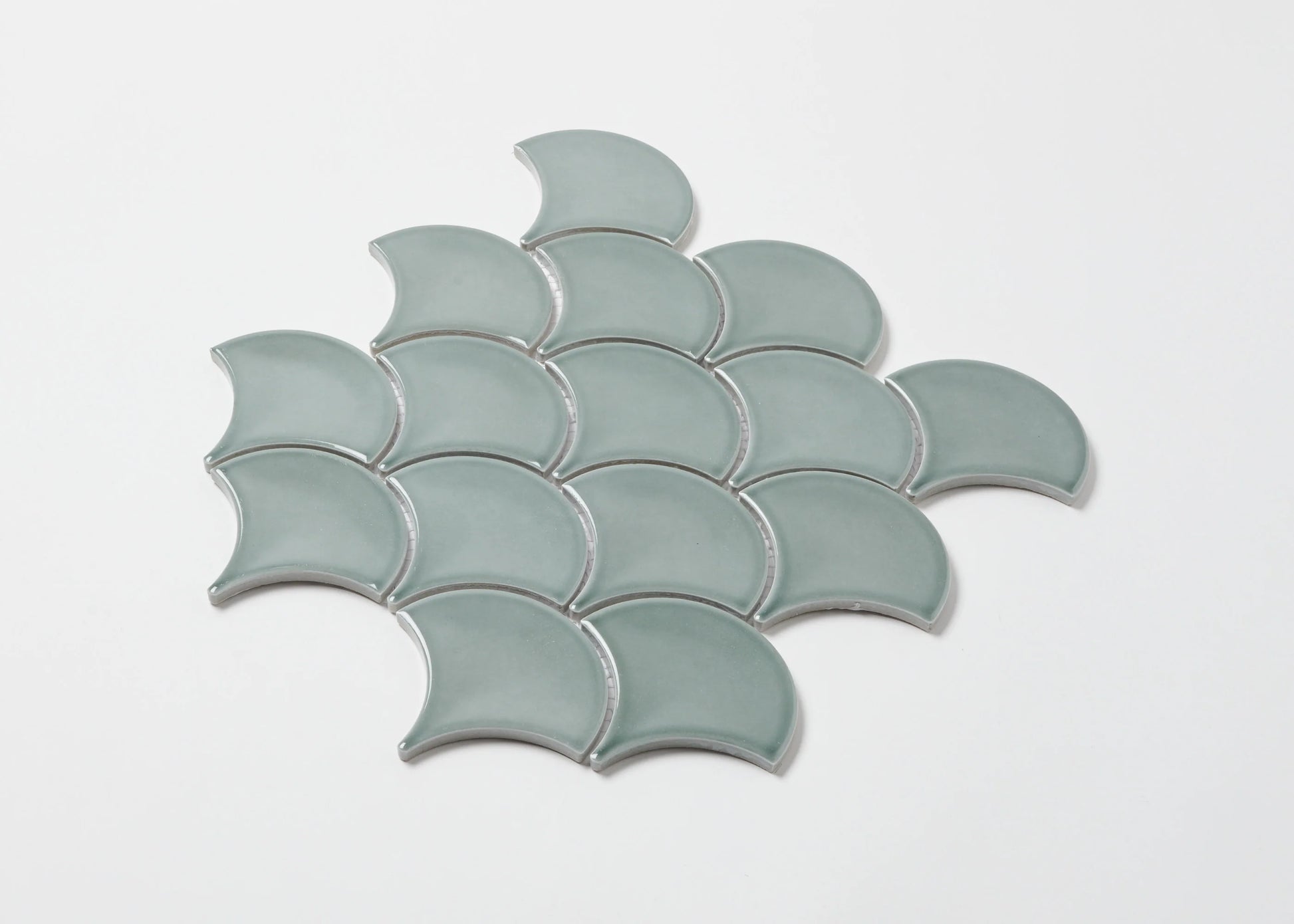 Pack shot of PGFS-8182 Water Green Gloss Glazed Porcelain Fishscale 95x87mm tiles arranged in an overlapping scale pattern with a soft aqua gloss finish.