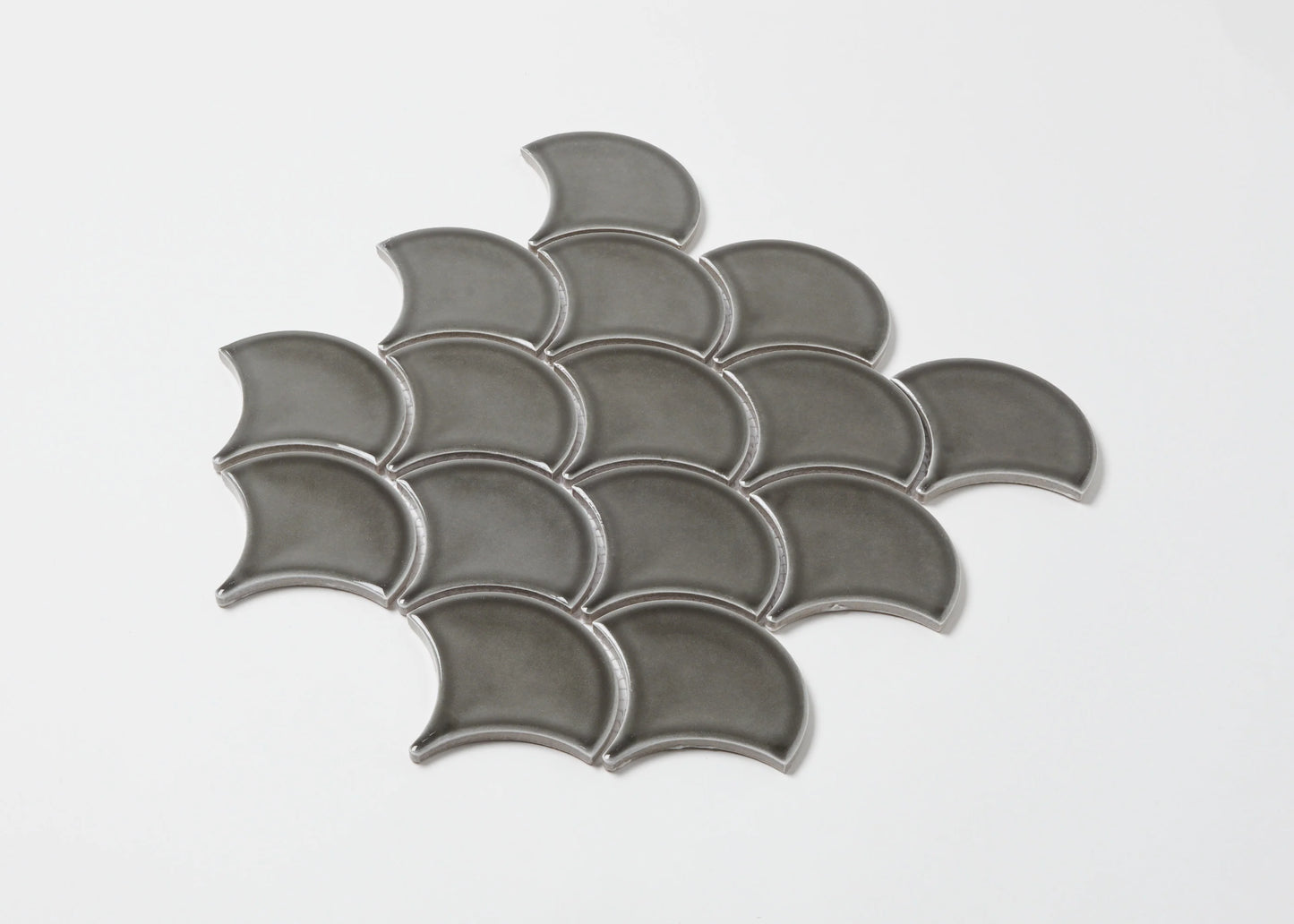 Pack shot of PGFS-8874 Charcoal Gloss Glazed Porcelain Fishscale 95x87mm tiles arranged in an overlapping fish scale pattern with a glossy grey finish.