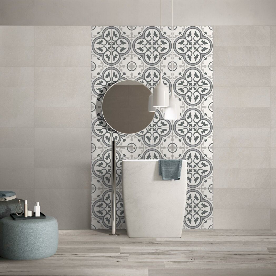 Picasso Fleur 200x200mm grey and white ornate patterned tiles installed as a bathroom feature wall behind a freestanding pedestal basin and round mirror.