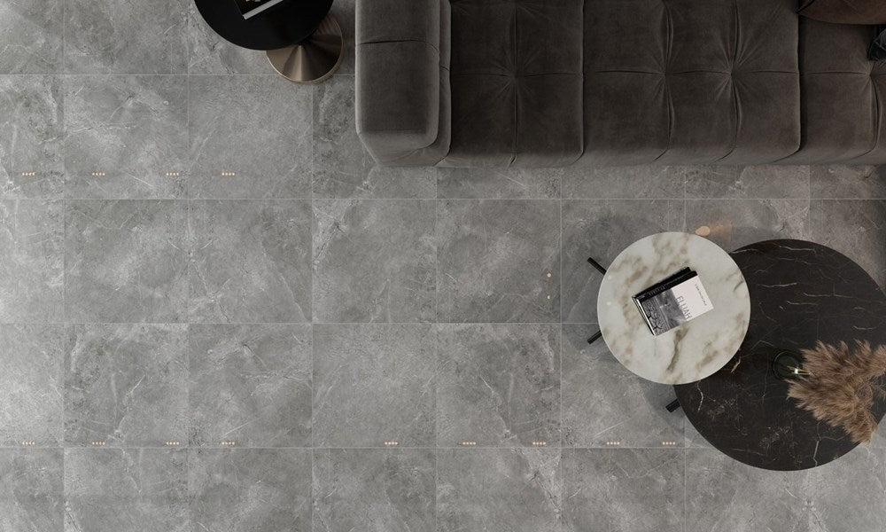 Potifino Nero Matt 600x600mm grey marble-effect floor tiles styled in a luxury living room with a tufted velvet sofa and marble coffee tables.