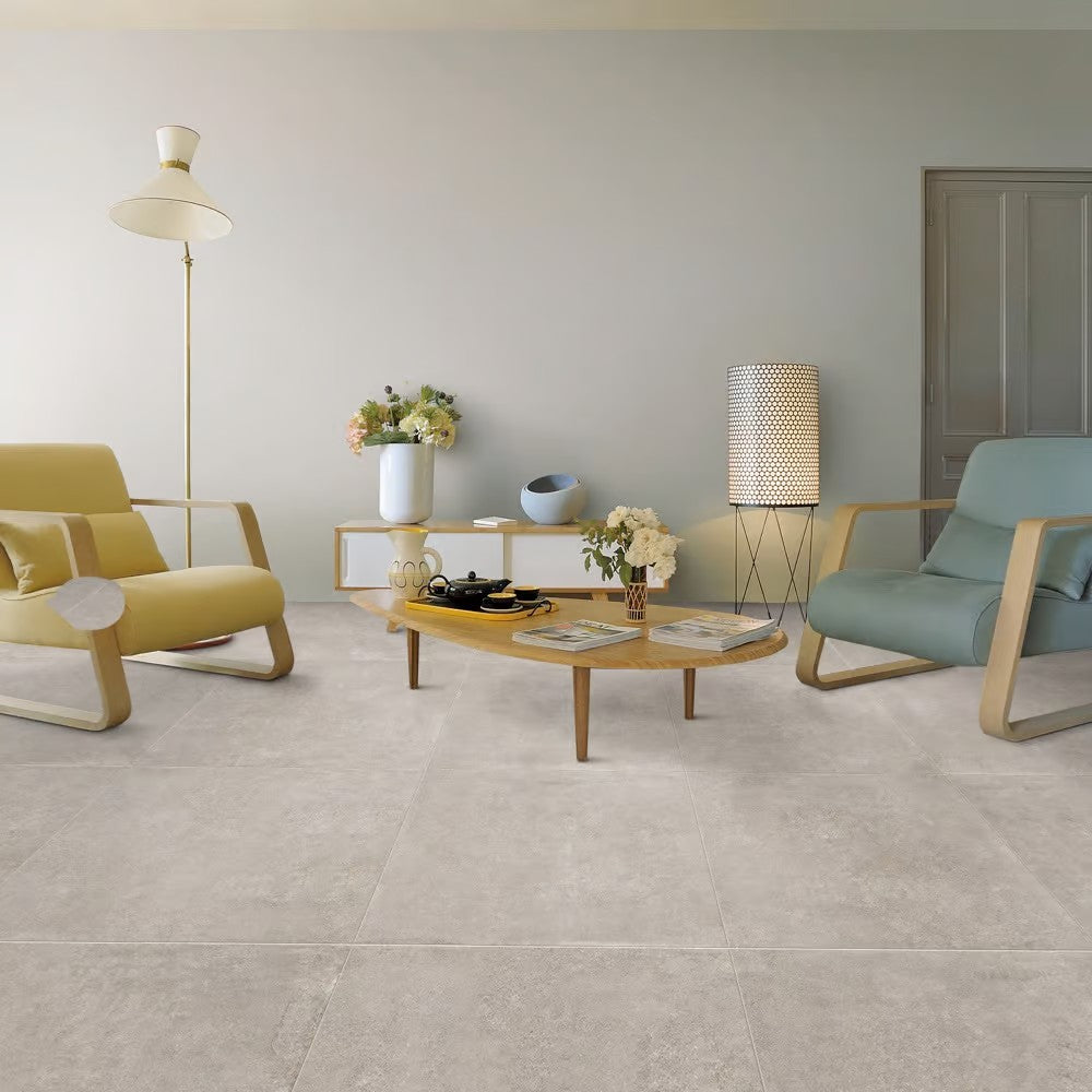 Prescott Greige Matt Rectified 300x600 tiles installed as a living room floor, paired with mid-century armchairs, a wooden coffee table, and floor lamps.