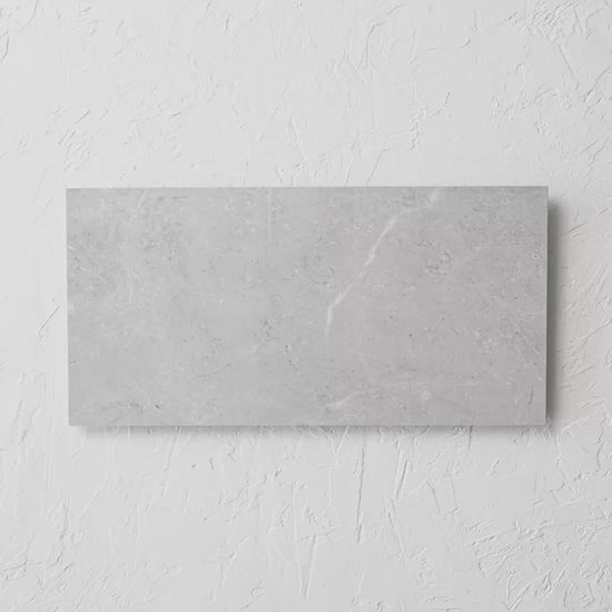 Bora Light Grey Polished Rectified 300X600Mm tile shown in hand