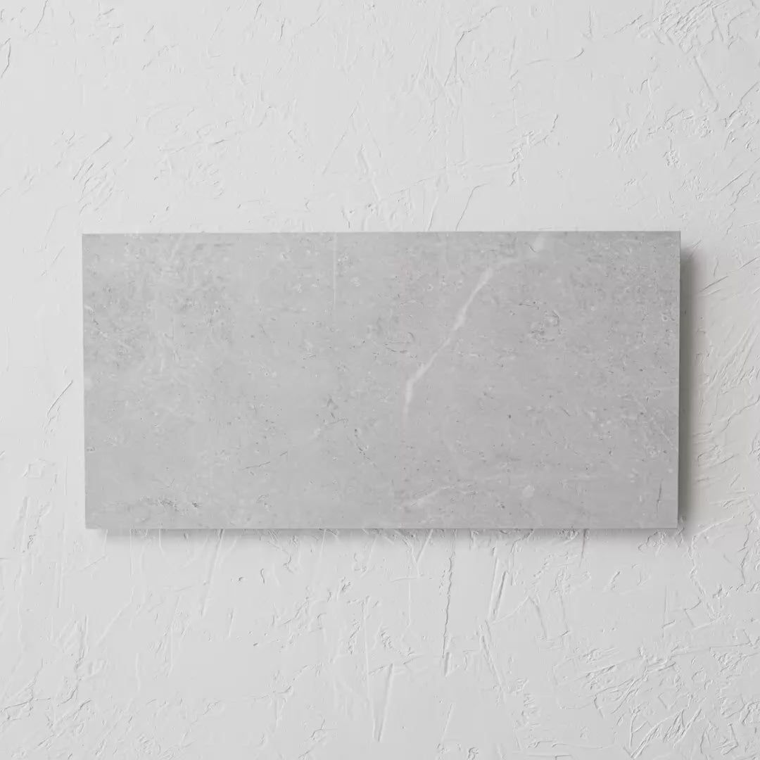 Bora Light Grey Polished Rectified 300X600Mm tile shown in hand