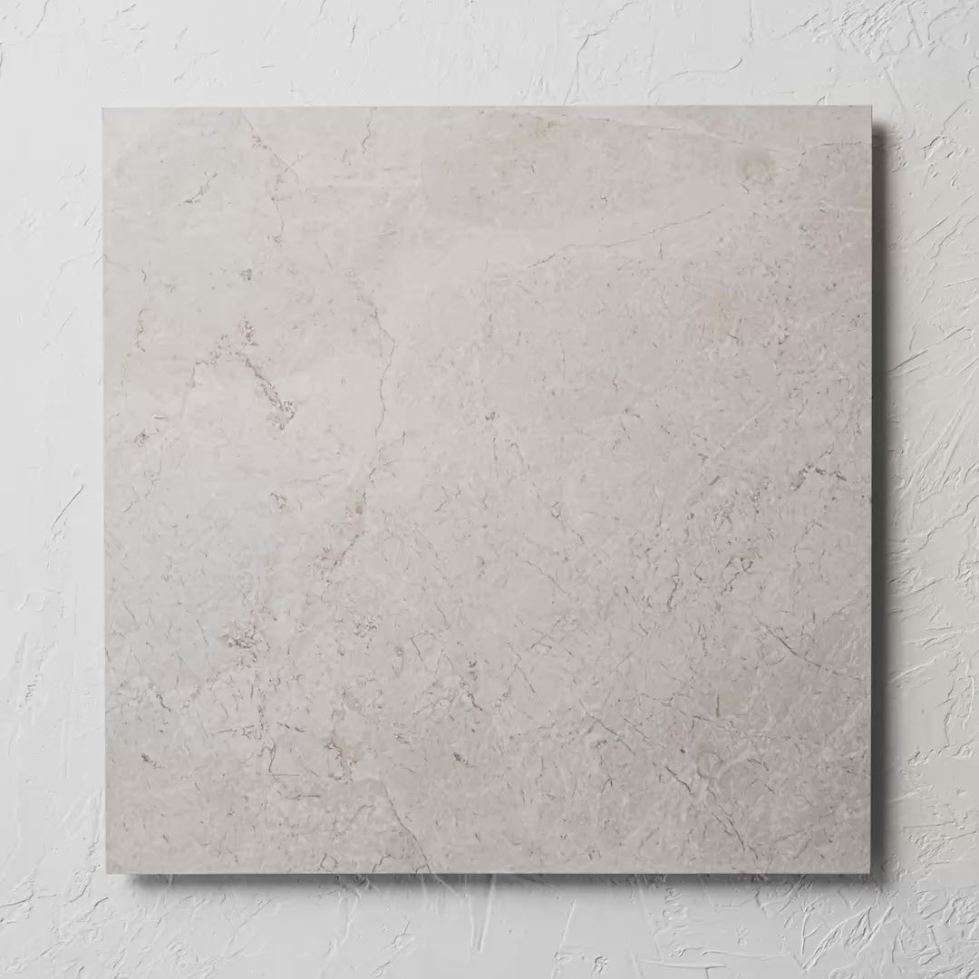 Riviera Ivory 600X600Mm tile shown in hand