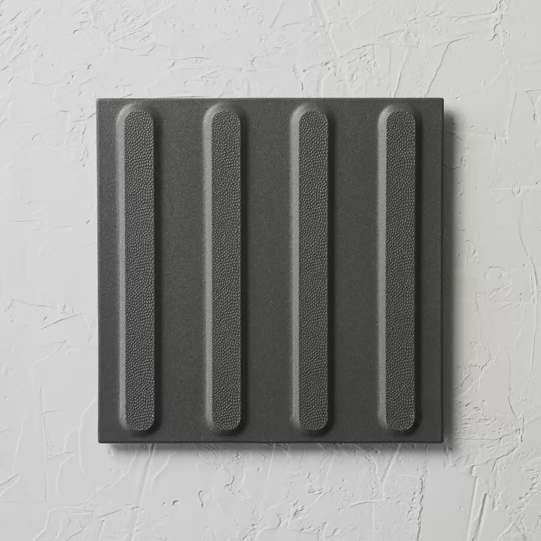 Directional Black Non Slip Tactile 300X300Mm tile shown in hand