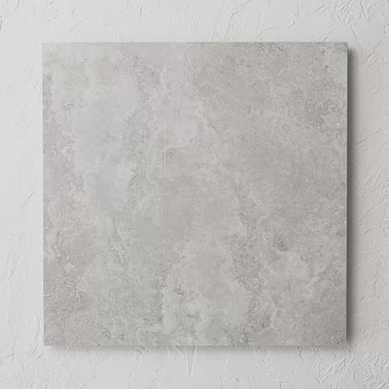 New Travertino Ivory Polished Rectified 600X600Mm tile shown in hand