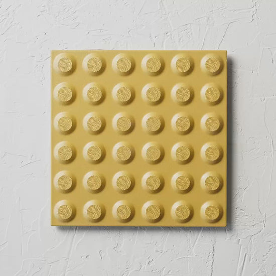 Hazard Yellow Non Slip Tactile 300X300Mm tile shown in hand
