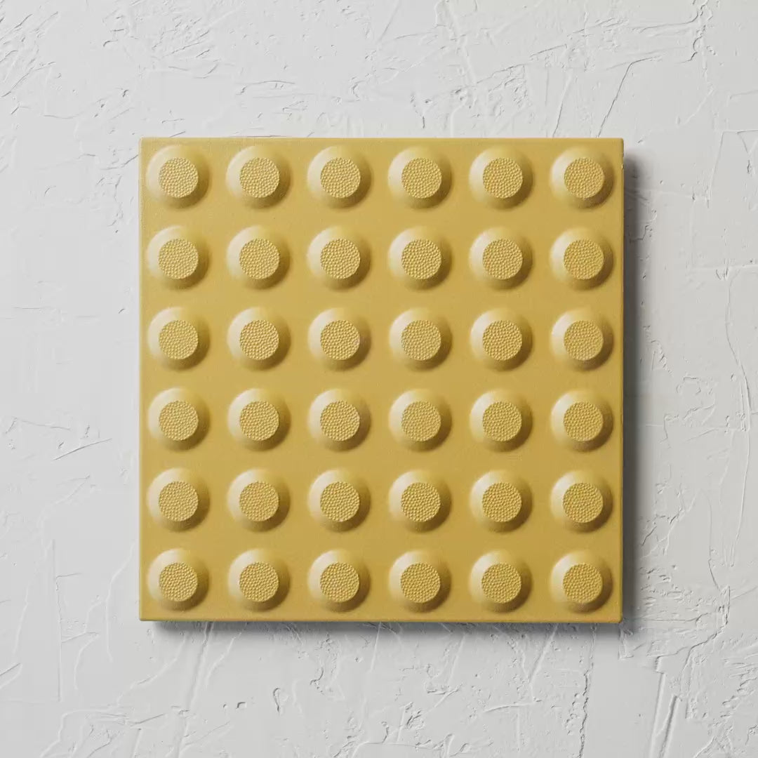 Hazard Yellow Non Slip Tactile 300X300Mm tile shown in hand