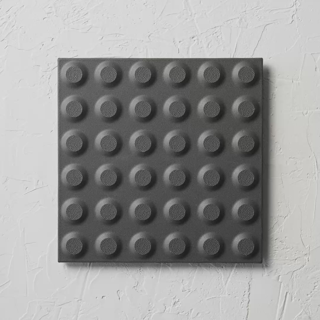 Hazard Black Non Slip Tactile 300X300Mm tile shown in hand