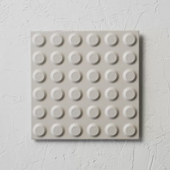 Hazard White Non Slip Tactile 300X300Mm tile shown in hand