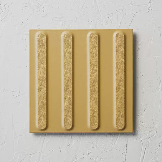 Directional Yellow Non Slip Tactile 300X300Mm tile shown in hand