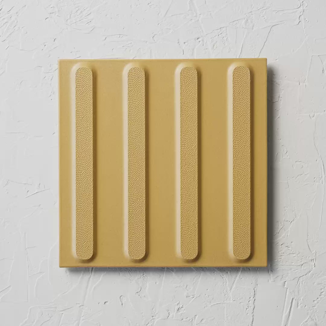 Directional Yellow Non Slip Tactile 300X300Mm tile shown in hand