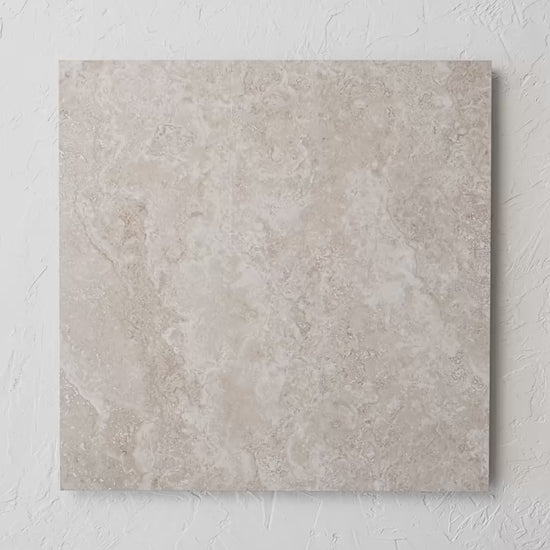 New Travertino Beige Polished Rectified 600X600Mm tile shown in hand