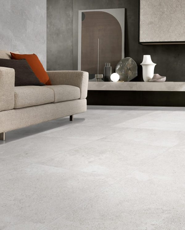 Provence Bianco Lapatto Rectified 600x600mm tiles installed as a living room floor, complementing a beige sofa and dark feature wall with decorative console.