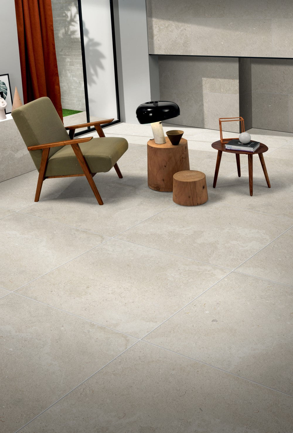 Provence Nature Rectified Inout 600x600mm light beige stone-look floor tiles installed in a modern living room with a mid-century armchair and timber side tables.