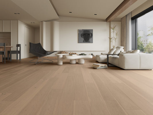 Raw White Classique Oak Flooring 14/2mm installed in a spacious open-plan living room with a cream sofa, sculptural coffee table, and large windows.