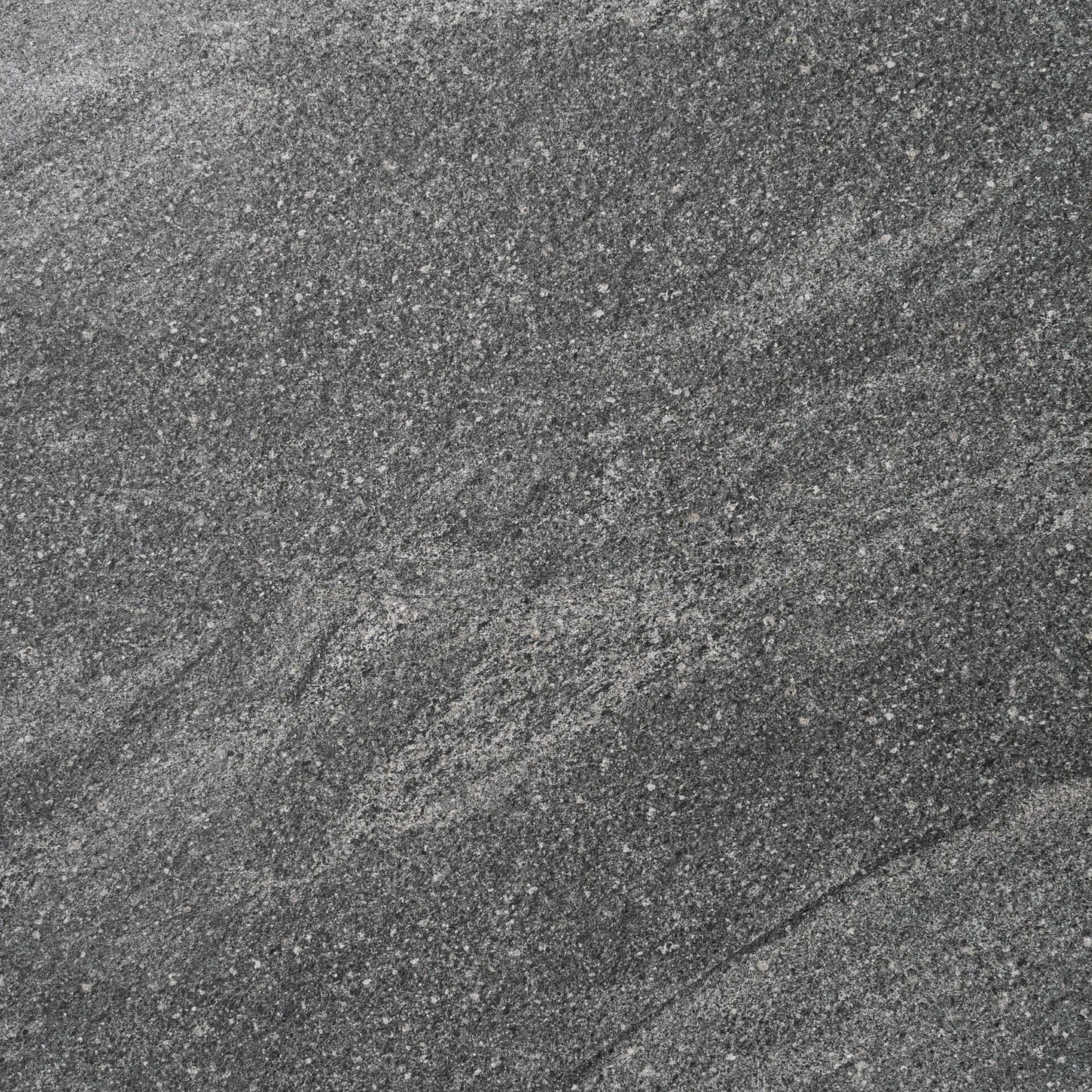 Close-up texture of the River Stone Dark Grey External Rectified Paver 600x600x20mm showing a fine-grained dark grey stone surface with natural mineral speckles and subtle veining.