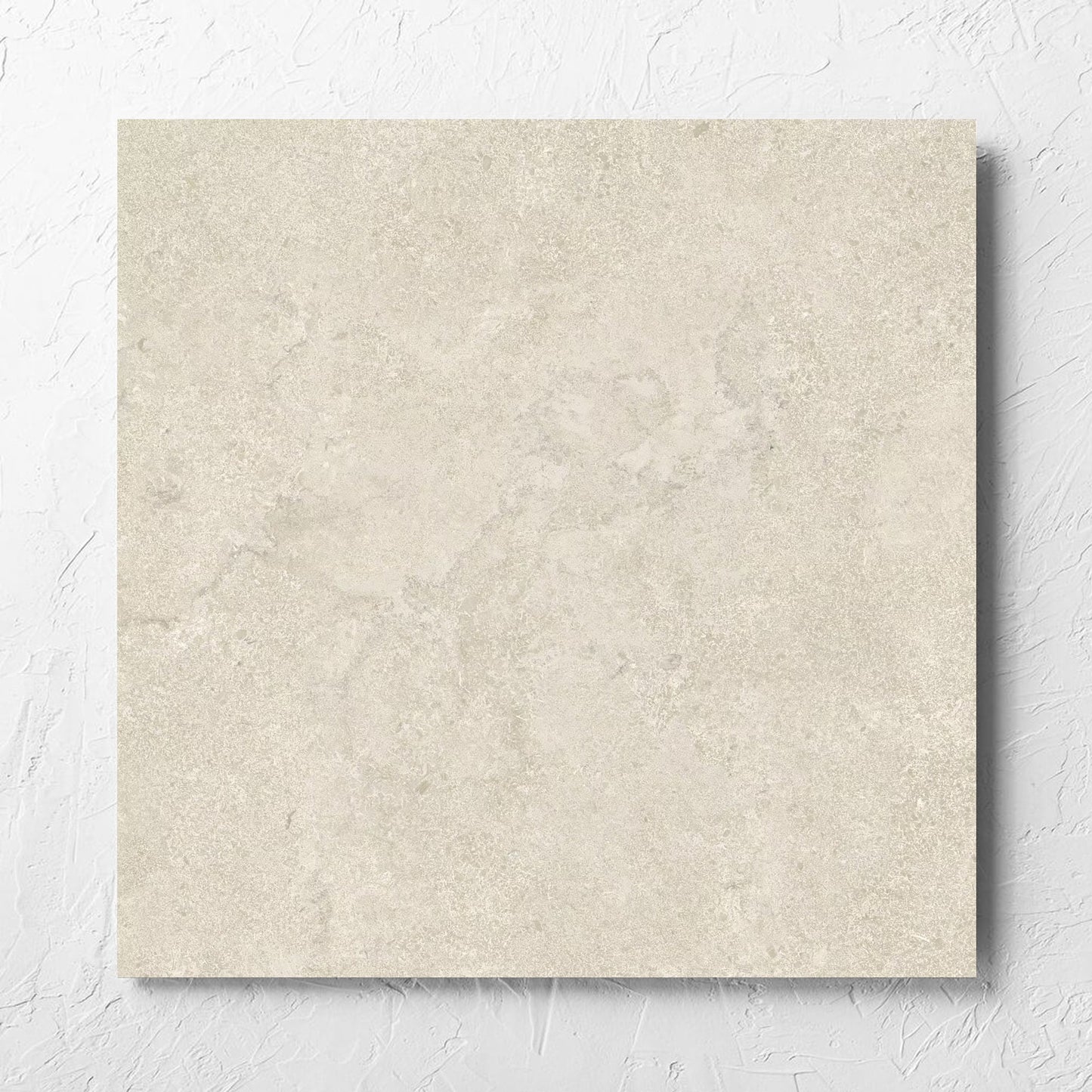 Roman Travertine Beige 600x600mm tile laid flat on a white rendered wall, showing the beige matt surface