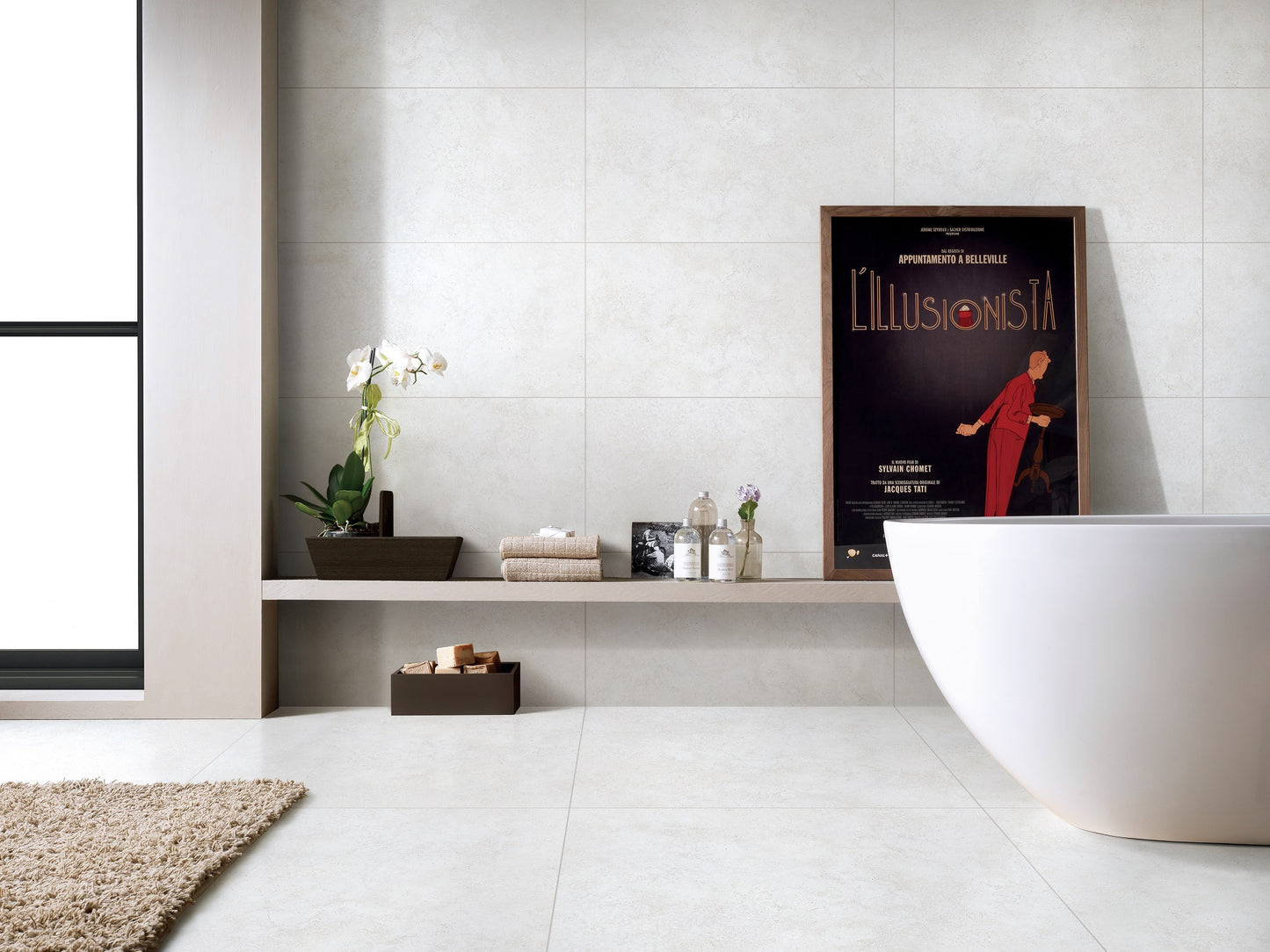 Roslin Dust Lapatto Rectified 300x600mm tiles covering the walls and floor of a modern minimalist bathroom featuring a freestanding white bathtub and built-in shelf.